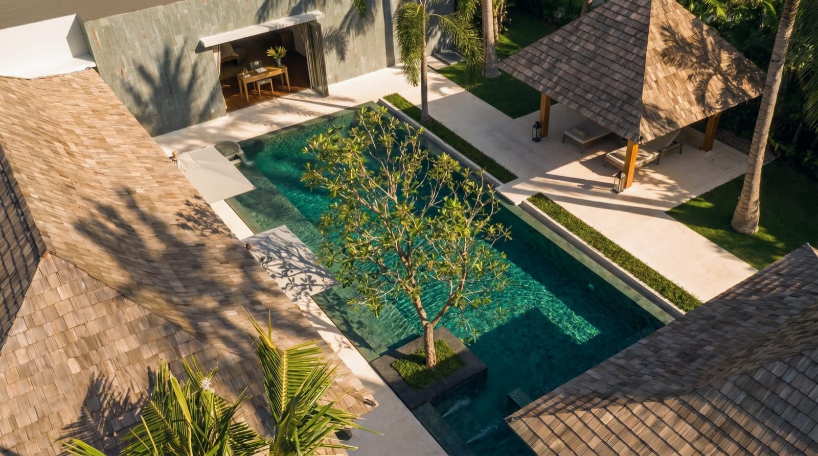 Aerial view of a private pool villa among palm trees on Phuket's north-west coast